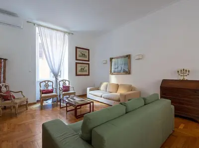 a living room with a green couch and chairs at Giulia Luxury Two Bedroom Apartment in Rome