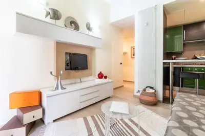a living room with a tv and a kitchen at Appartamento Celio in Rome