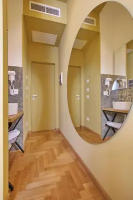 a hallway with a round mirror in a bathroom at Dreaming Rome Suites in Rome