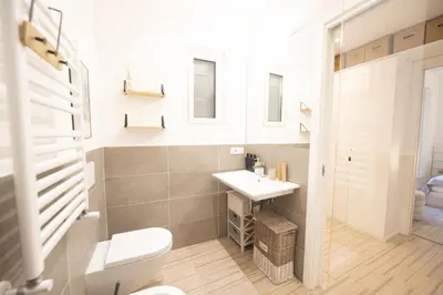 a bathroom with a white toilet and a sink at Vintage and Design in the Heart of Vibrant Pigneto in Rome