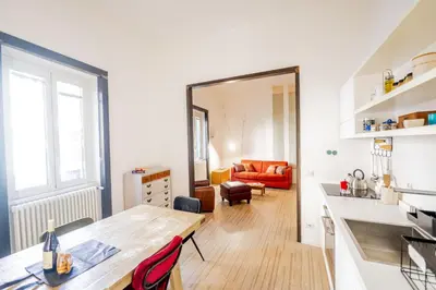 a kitchen and living room with a wooden table in a room at Vintage and Design in the Heart of Vibrant Pigneto in Rome