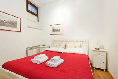 a bedroom with a red bed with two towels on it at Navona 360 in Rome