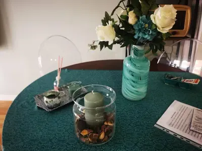 a table with a vase and a candle and flowers at La verde dimora in Rome
