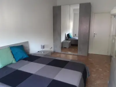 a bedroom with a large bed and a mirror at Camera matrimoniale vicino a San Pietro in Rome