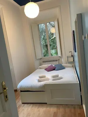 a small bedroom with a white bed and a window at La Casa Romana in Rome