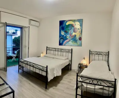 two beds in a room with a painting on the wall at AmoRoma Holiday in Rome