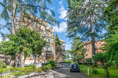 a street in front of a building with trees at AmoRoma Holiday in Rome