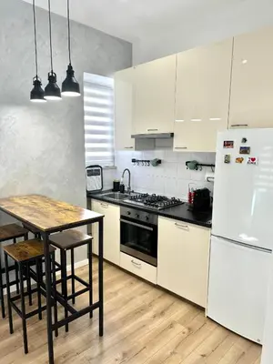 a kitchen with white cabinets and a table and a refrigerator at Maddalena Means Home in Rome