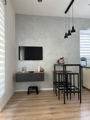 a living room with a table and a television on a wall at Maddalena Means Home in Rome