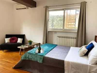 a bedroom with a bed and a couch and a window at Bright Penthouse 2 M stops from Vatican Museums in Rome