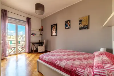 a bedroom with a bed and a window and a desk at GuestHost - MM Re di Roma Apartment in Rome