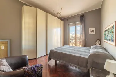 a bedroom with a bed and a couch and a window at GuestHost - MM Re di Roma Apartment in Rome
