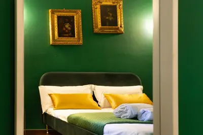 a green wall with a couch with two pillows at TP Apartment Luxury Colosseum in Rome