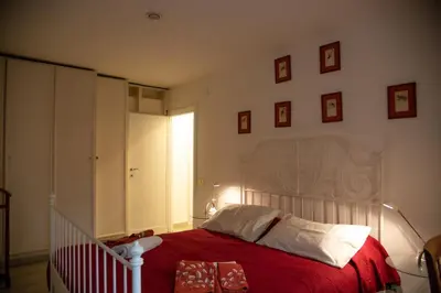 a bedroom with a large bed with a red blanket at Aventino apartment in Rome
