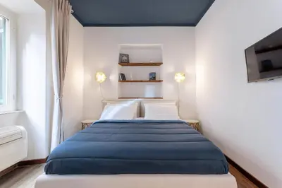a bedroom with a bed with a blue blanket at Suite Vaticano in Rome