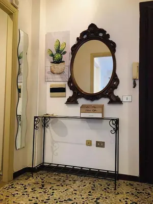 a mirror on a wall next to a table at Appartamento di Sara in Rome