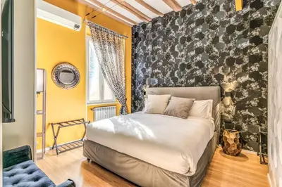 a bedroom with a bed and a yellow wall at Castel Sant'Angelo SuiteLux in Rome