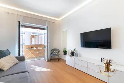 a living room with a couch and a tv on a wall at Silverius - Roma's Delightful Lodges in Rome