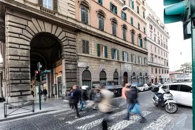 a group of people crossing a street in front of a building at Vanella Rome Domus in Rome