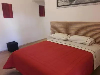a bedroom with a large bed with a red blanket at Rizzola casa e appartamento per vacanze in Rome