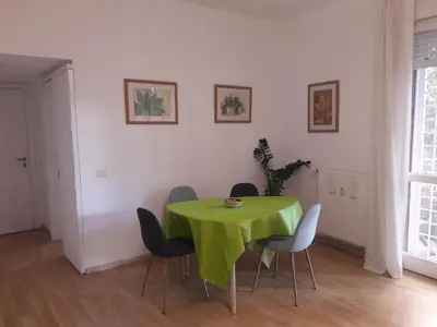 a dining room with a green table and chairs at Rizzola casa e appartamento per vacanze in Rome