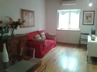 a living room with a red couch and a window at Barberini 360 in Rome