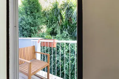 a wooden chair sitting on a balcony at DomusFebo-VaticanSuites in Rome