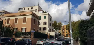 a street with cars parked in front of a building at Trastevere Residenze in Rome