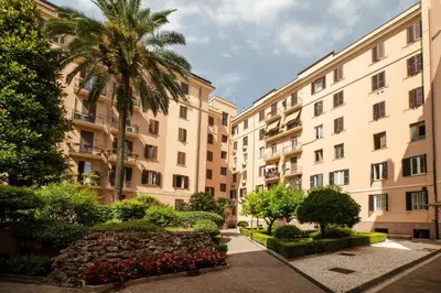 a row of apartment buildings with palm trees and bushes at Domus Pietrae in Rome