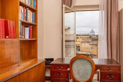 a desk with a chair in a room with a window at Skyline Penthouse with Private Rooftop in Rome