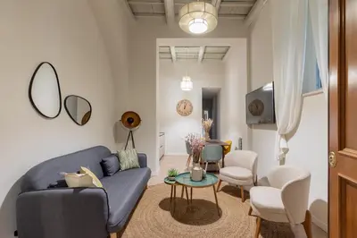 a living room with a blue couch and a table at Corso Caesar Suites in Rome