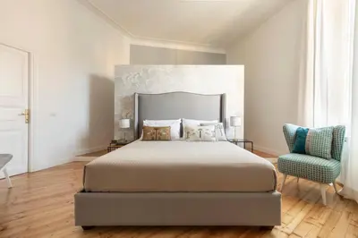 a bedroom with a large bed and a blue chair at Elegante Dimora a Trastevere in Rome