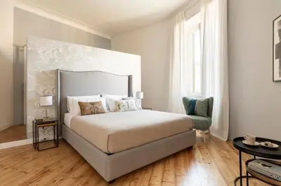 a bedroom with a large bed and a chair at Elegante Dimora a Trastevere in Rome