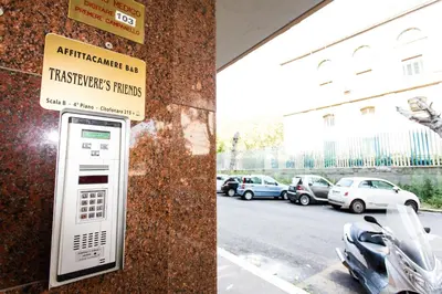 a ticket machine on the side of a building with parked cars at Trastevere's Friends in Rome