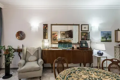 a living room with a chair and a mirror at Appartamento Roma Centro in Rome