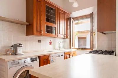 a kitchen with wooden cabinets and a counter top at Elegant & Quiet Apartment next to Colosseo in Rome
