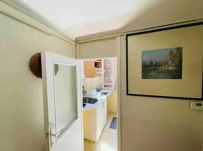 a kitchen with a painting on the wall and a door at A Place in Prati in Rome