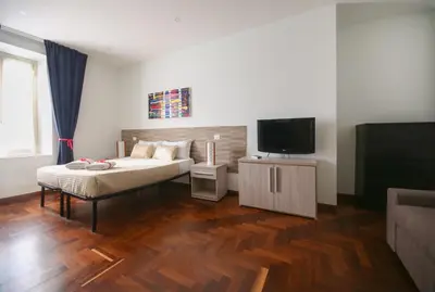 a bedroom with a bed and a flat screen tv at Rome Aparts - Deluxe Apartment with 3 bedrooms at St Peter square in Rome
