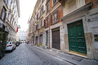 an alley with a green door on a building at Elisa's Trevi Fountain BuddyRent in Rome