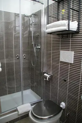 a bathroom with a shower and a toilet with a glass door at Rome Orange Inn in Rome