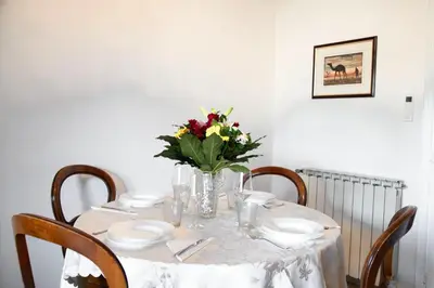 a dining room table with a vase of flowers on it at AURELIA LORIS HOUSE in Rome