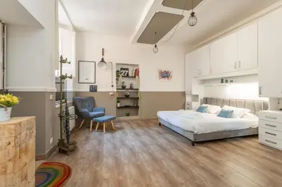 a bedroom with a bed and a chair in it at Central Charm near Piazza Navona - Cozy Loft for 2 in Rome