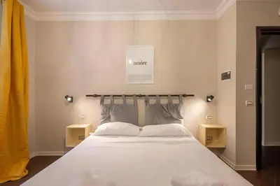 a bedroom with a bed with two night stands at Ghetto BuddyRent in Rome