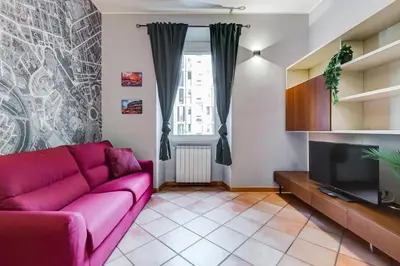 a living room with a purple couch and a tv at Historia et Elegantia - vicino il Colosseo, Circo Massimo e Trastevere in Rome