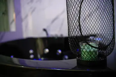 a black bathroom sink with a green candle in it at Matriosca Suites in Rome
