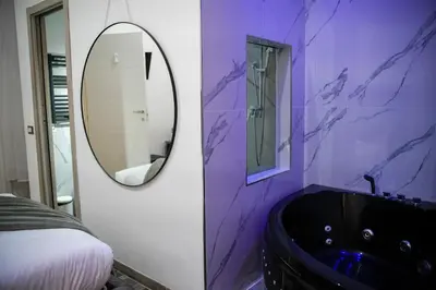 a black tub in a bathroom with a ladder at Matriosca Suites in Rome