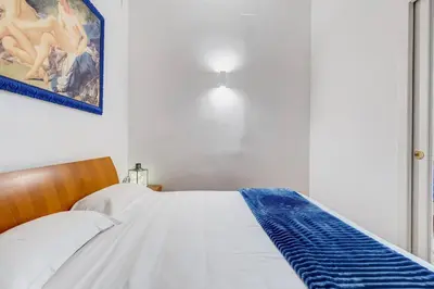 a bedroom with a bed with a blue blanket on it at Clemente XII Al Quirinale House in Rome