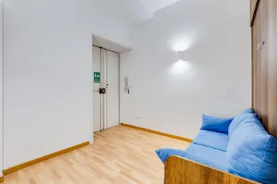 a living room with a blue couch and a door at Clemente XII Al Quirinale House in Rome