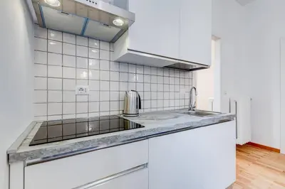 a white kitchen with a sink and a stove at Clemente XII Al Quirinale House in Rome
