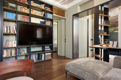 a living room with a large tv and bookshelves at Casa MastroiannI con Terrazzo in Rome